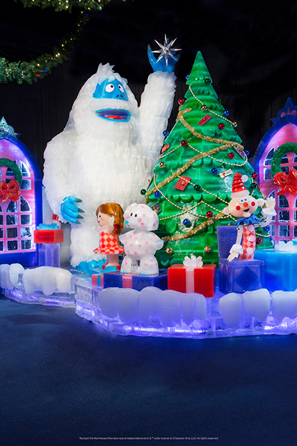 Characters made of ice stand around a Christmas tree