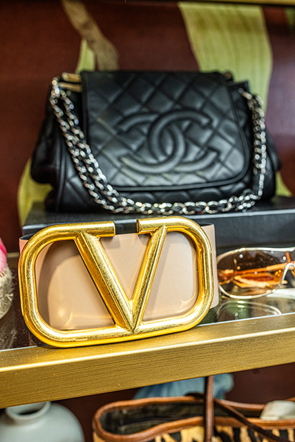 A black handbag sits on a shelf