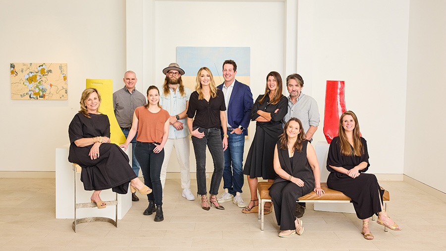 A group of people pose inside an art gallery