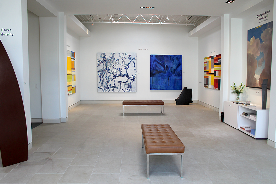 Blue, white and black art hangs on the wall of an art gallery