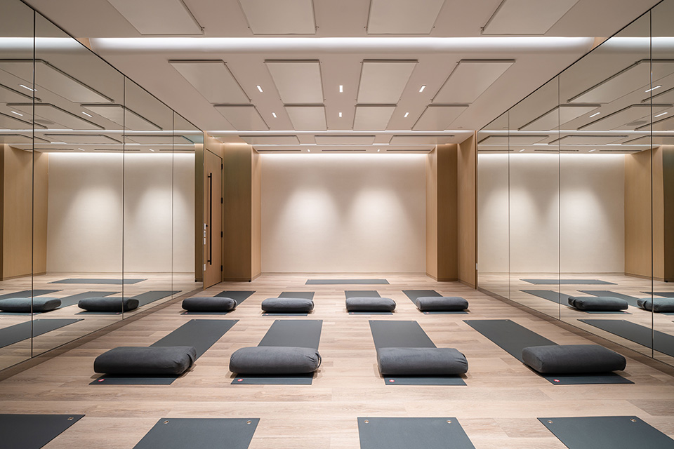 Yoga mats line a room at Canyon Ranch Wellness Center, surrounded by warm wood and walls of mirrors.