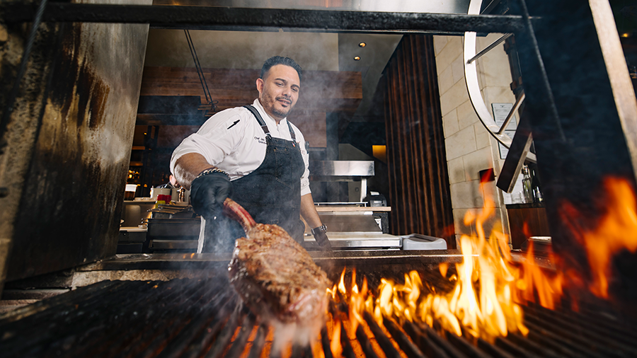 Executive Chef Julio Cartagena grills the 52-ounce Tomahawk Ribeye inside Toro Toro restaurant.