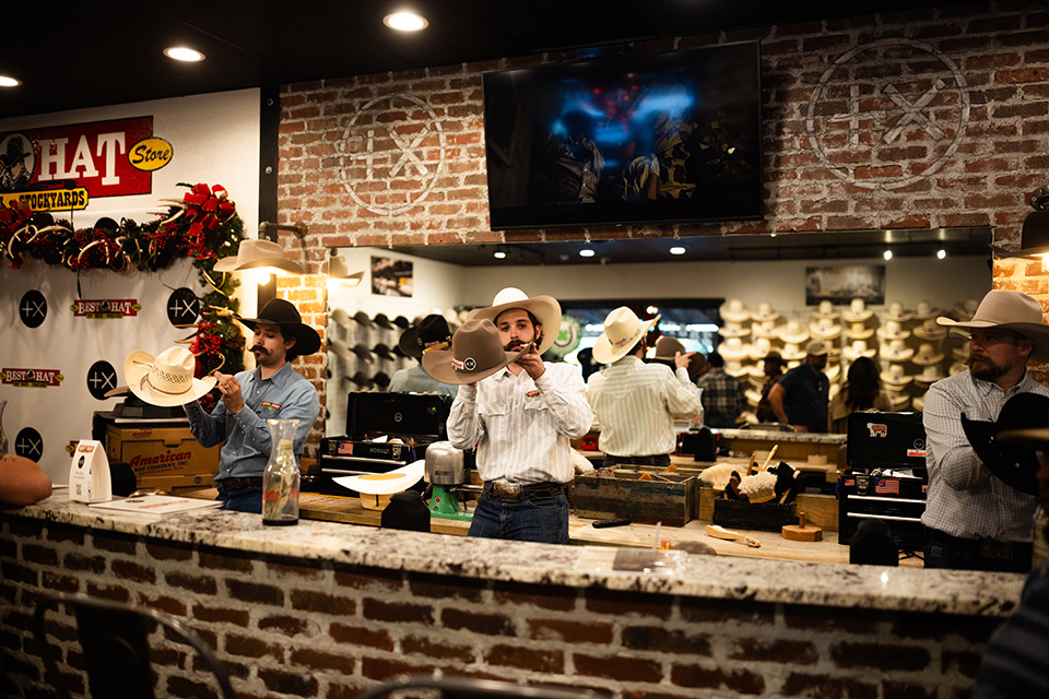 The team at The Best Hat Store stands behind the counter creating custom hats.