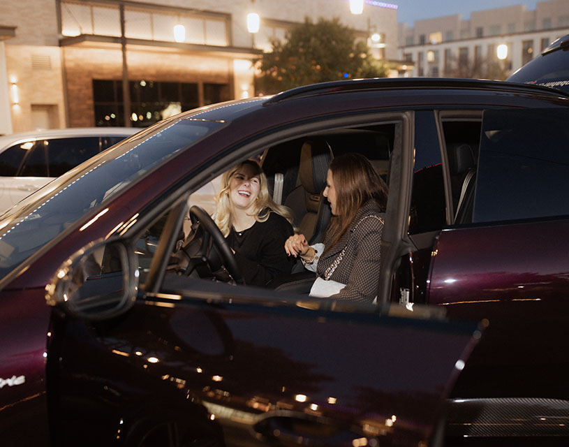 Attendees sit in the front of a new car provided by Autobahn at the 360West Fall Fashion event.