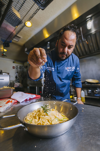 A dash of seasoning adds the finishing touch to a pasta dish at Loveria