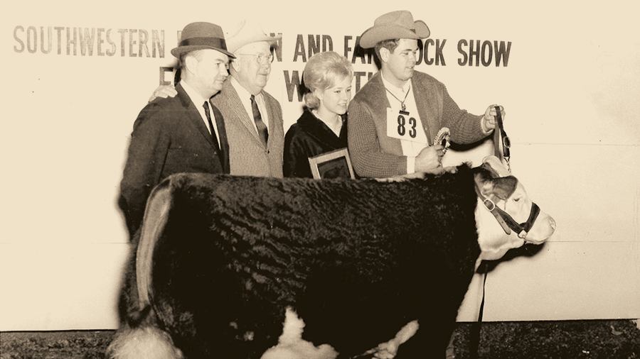 Grand Champion steer Jack stands with 4 people for a photo