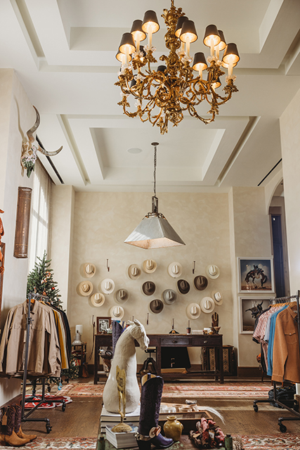 A wall of Western hats is featured alongside racks of shirts and jackets.