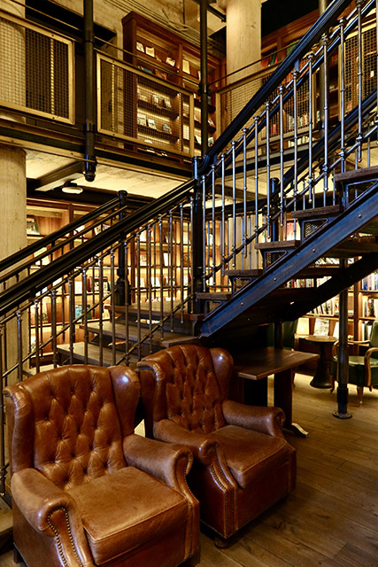 A staircase in the two-story library at Hotel Emma.