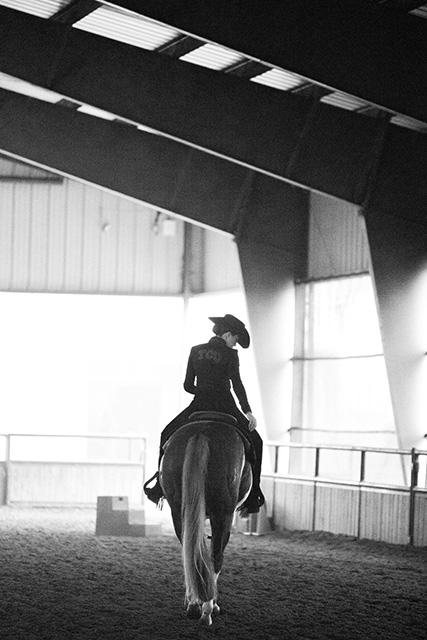 One TCU equestrian's student-athletes rides a horse in an arena.