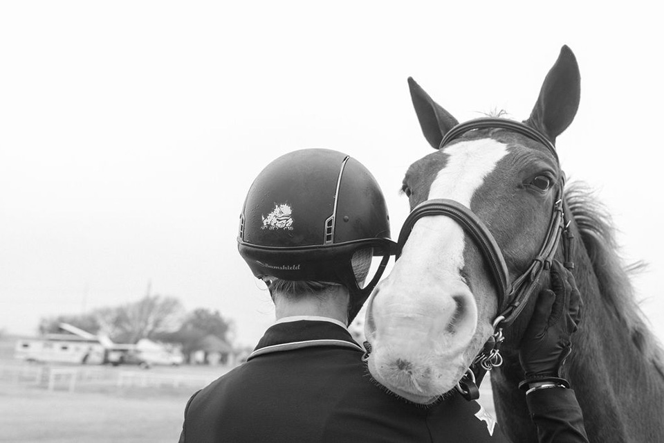 A horse looks over the shoulder of TCU equestrian's student-athlete.