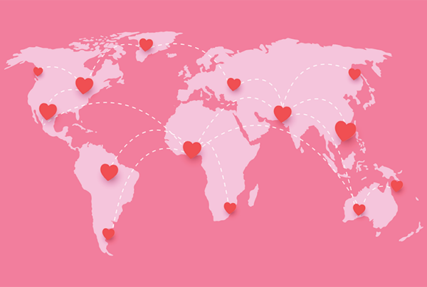 A pink graphic of a world map, showing hearts all across the world