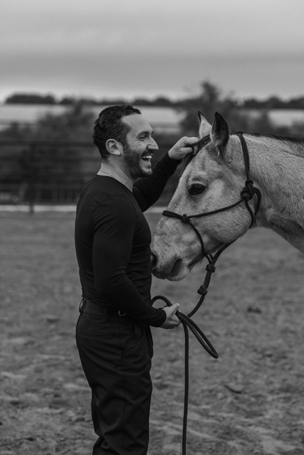 Emerson Miller stands with a horse, laughing