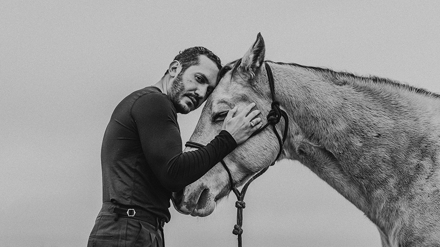 Photorapher Emerson Miller stands with a horse